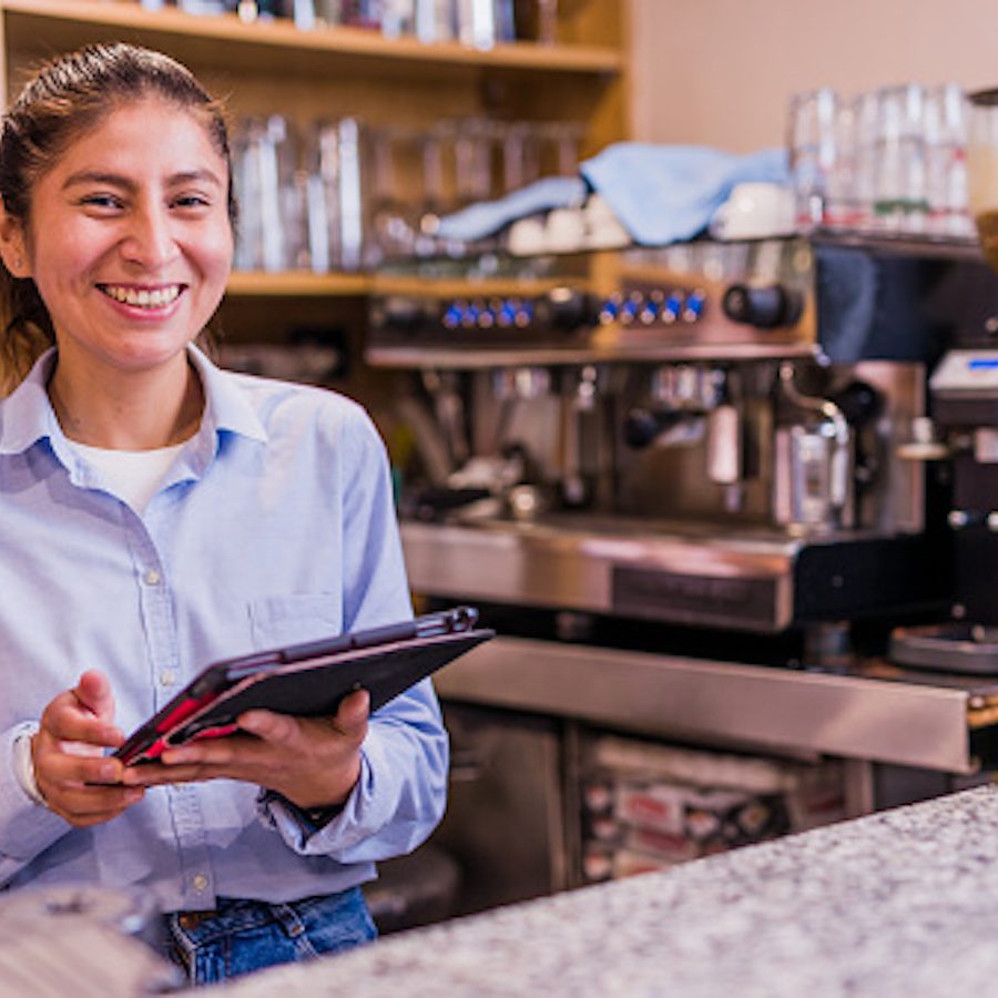 south America Peru cafe bar owner. female waitress using technology from a tablet and internet.